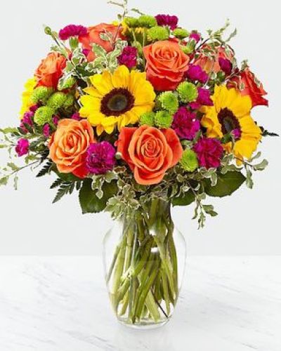 The Color Craze Bouquet blooms with a vibrant energy to create a special moment for your recipient! Our floral professionals weave together a blend of orange roses, sunflowers, violet mini carnations, green button poms, and lush greens to create an incredible gift. Presented in a clear glass vase, this truly colorful display of fresh flowers is ready to send your warmest birthday, thank you, or get well wishes straight to their door.
STANDARD bouquet is approx. 15H x 12W.
DELUXE bouquet is approx. 15H x 13W.
PREMIUM bouquet is approx. 16H x 14W.